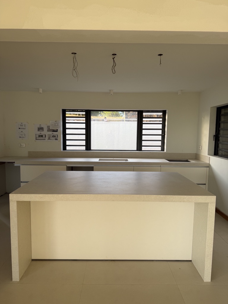 Villa Privée — Cuisine pierre beige, îlot waterfall